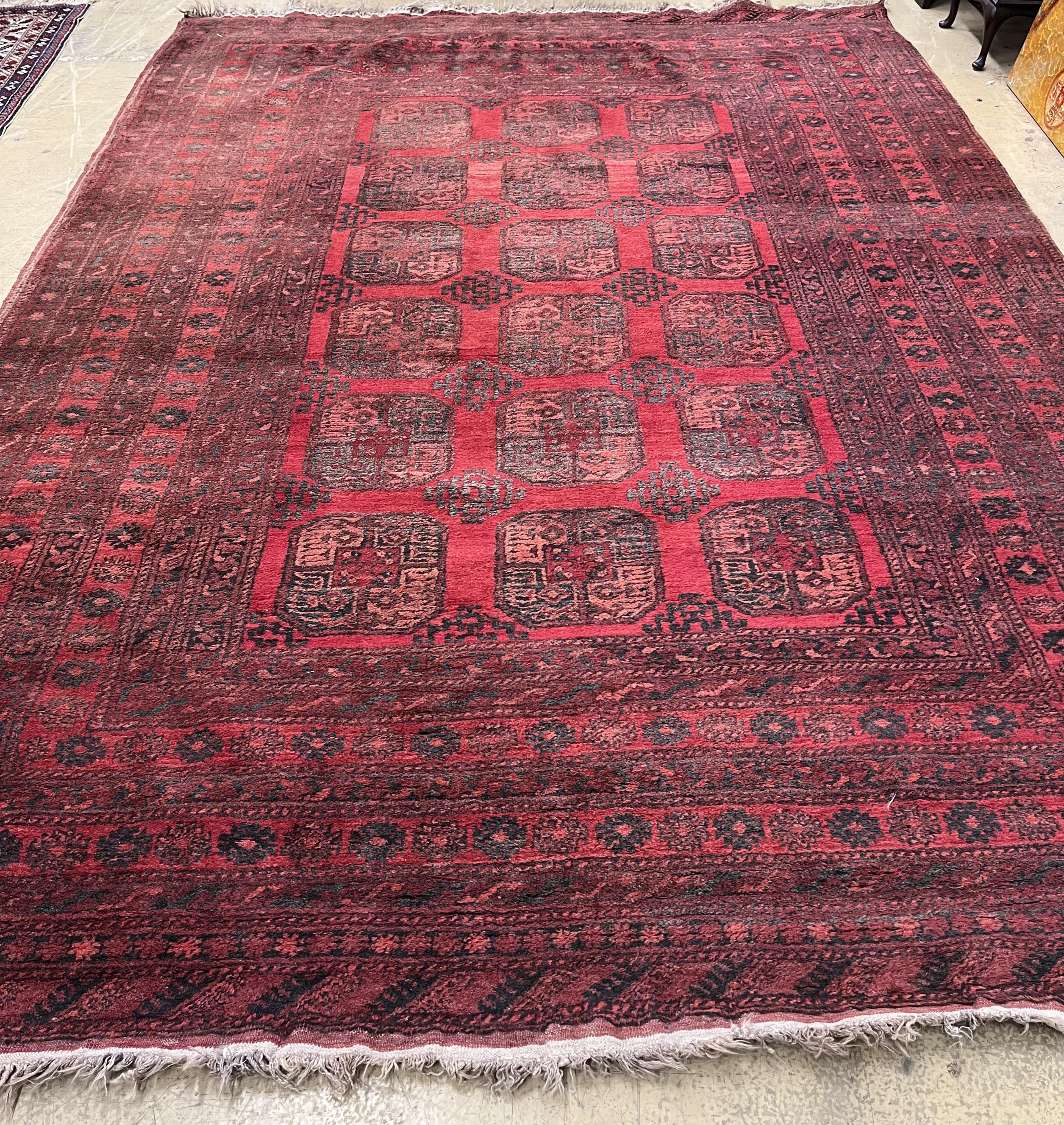 An Afghan red ground carpet, 330 x 240cm. Condition - fair